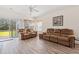 Bright living room featuring two sofas, wood floors, a ceiling fan, and a sliding glass door with outdoor views at 6000 Windsor Green Way # 104, Myrtle Beach, SC 29579