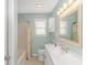 Bathroom with white vanity, toilet, and shower with curtain and fixtures at 6001- 8005 S Kings Hwy., Myrtle Beach, SC 29575