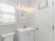 Fresh bathroom with a white vanity, mirror, and fixtures, complemented by a window offering natural light at 6001- 8005 S Kings Hwy., Myrtle Beach, SC 29575