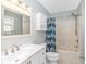 Bathroom with white vanity and updated shower with blue curtain and fixtures at 6001- 8005 S Kings Hwy., Myrtle Beach, SC 29575