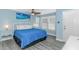 Bright bedroom with queen bed, fan, and beach painting over the headboard at 6001- 8005 S Kings Hwy., Myrtle Beach, SC 29575