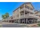 Coastal home on stilts, boasting multiple balconies, covered parking, and beachy charm against a clear blue sky at 6001- 8005 S Kings Hwy., Myrtle Beach, SC 29575