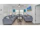 Bright living room featuring light gray couches, coastal artwork, ceiling fan, and a wall-mounted television at 6001- 8005 S Kings Hwy., Myrtle Beach, SC 29575