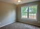 Bedroom with light walls, carpeted floor, ceiling fan, and a window overlooking front yard at 608 Miles Ct, Marion, SC 29571