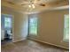Bright bedroom featuring a tray ceiling, ceiling fan, neutral walls and carpet, and an adjoining bathroom at 608 Miles Ct, Marion, SC 29571
