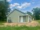 Back exterior view of a light green home with black roof and an AC unit at 608 Miles Ct, Marion, SC 29571
