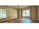 Well-lit bedroom with hardwood floors and large windows providing ample natural light and outdoor views at 618 Wintercreeper Dr., Longs, SC 29568