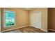 Simple bedroom with a window, closet, neutral walls, and wood-look flooring at 618 Wintercreeper Dr., Longs, SC 29568