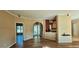 Bright living room featuring wood floors, arched doorway, and view to the kitchen at 618 Wintercreeper Dr., Longs, SC 29568