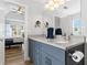 Bathroom featuring double sinks, blue cabinets and views to the main bedroom at 620 Seth Ln., Longs, SC 29568