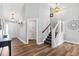 Open entryway featuring wood floors, a staircase, and an adjacent laundry room for convenience at 620 Seth Ln., Longs, SC 29568