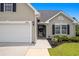 Close-up view of a home's front entrance, highlighting the well-lit walkway and manicured flowerbeds at 620 Seth Ln., Longs, SC 29568