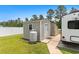 Outdoor storage shed with gray vinyl siding and a white vinyl fence at 620 Seth Ln., Longs, SC 29568