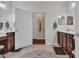 Well-lit bathroom with dual vanities, tile floors, and a door leading to the hallway at 628 Grand Cypress Way, Murrells Inlet, SC 29576