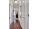 Well-lit hallway featuring hardwood floors and multiple white doors, creating a seamless transition between rooms at 628 Grand Cypress Way, Murrells Inlet, SC 29576