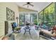 Relaxing screened porch with comfortable seating, ceiling fan, and views of the lush greenery at 628 Grand Cypress Way, Murrells Inlet, SC 29576