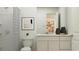 Clean, modern bathroom with white fixtures, a framed art piece, and shower with a decorative curtain at 6366 Swainson Street Sw, Ocean Isle Beach, NC 28469