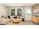 Spacious living room featuring modern furnishings, neutral tones, a large window, and stylish decor at 6366 Swainson Street Sw, Ocean Isle Beach, NC 28469
