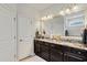 Double vanity bathroom with granite counters, dark cabinets, and a large framed mirror at 6378 Torino Lane, Myrtle Beach, SC 29572