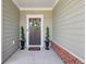 Elegant front door adorned with a wreath, flanked by topiaries, providing a warm welcome to the home at 6378 Torino Lane, Myrtle Beach, SC 29572