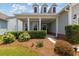 Inviting front porch featuring decorative shrubbery, a well-manicured lawn, and a charming entrance area at 6378 Torino Lane, Myrtle Beach, SC 29572