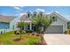 Inviting front yard with green lawn, mature crepe myrtle trees, and a two-car garage, creating a welcoming curb appeal at 6378 Torino Lane, Myrtle Beach, SC 29572