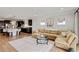 Cozy living room featuring a sectional sofa, modern lighting, and hardwood floors leading to the kitchen at 6378 Torino Lane, Myrtle Beach, SC 29572