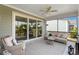 Relaxing screened porch with wicker furniture and a glimpse of the landscaped yard at 6378 Torino Lane, Myrtle Beach, SC 29572