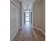 Well-lit hallway with wood floors, white trim, closet space, and a view of the front door at 648 Sunnyside Dr. # 102, Murrells Inlet, SC 29576