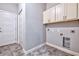 Functional laundry room with neutral gray walls, upper cabinets for storage and machines connections at 648 Sunnyside Dr. # 102, Murrells Inlet, SC 29576