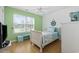 This bedroom has a white frame bed, and a turquoise accent wall with a beachy decoration at 6681 Wisteria Dr., Myrtle Beach, SC 29588