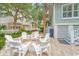 A backyard patio featuring outdoor seating and chairs centered around a brick patio with a manicured lawn at 70 Beachwalker Ct., Georgetown, SC 29440