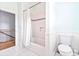 Clean, white bathroom with tiled floor and walls, featuring a tub with shower and toilet at 70 Beachwalker Ct., Georgetown, SC 29440