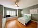Bright bedroom featuring a full-size bed, window seat with storage, and light hardwood floors at 70 Beachwalker Ct., Georgetown, SC 29440