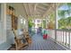 Spacious covered porch with comfortable seating arrangements, ceiling fans, and views of the neighborhood greenery at 70 Beachwalker Ct., Georgetown, SC 29440