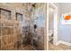 Custom tiled shower with built-in niches and decorative accent tiles, leading to a toilet at 70 Beachwalker Ct., Georgetown, SC 29440
