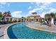 Community pool featuring a winding design, palm trees, and pergola seating areas at 7183 Shooting Star Way, Myrtle Beach, SC 29579