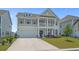Inviting two-story home showcasing a covered porch, balcony, and a freshly painted attached two-car garage at 753 Enchantment Loop, Myrtle Beach, SC 29588