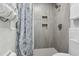 Modern tiled shower with built-in shelves and a decorative shower curtain at 800 9Th Ave. S # E-4, North Myrtle Beach, SC 29582