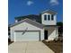 Two-story home featuring a two-car garage, bright white siding, black roof, and manicured landscaping at 859 Long Beach Dr, Longs, SC 29568