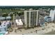 Aerial view of beachfront condo building, neighborhood, ocean and blue skies at 912 N Waccamaw Dr. # 904, Garden City Beach, SC 29576