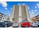 Exterior view of the Adam Towers condo building, parking lot, and a clear blue sky at 912 N Waccamaw Dr. # 904, Garden City Beach, SC 29576