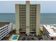 Oceanfront condo building with a pool and parking at 912 N Waccamaw Dr. # 904, Garden City Beach, SC 29576