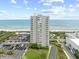 A multi-story condominium building by the ocean, with a parking lot and palm tree landscaping at 9820 Queensway Blvd. # 502, Myrtle Beach, SC 29572