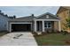 Charming single-story home featuring gray siding, a covered entrance, attached garage and a well-manicured front yard at 1043 Laconic Dr., Myrtle Beach, SC 29588
