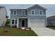 Two-story blue home featuring white trim, a two-car garage, and a well-manicured lawn at 1046 Laconic Dr., Myrtle Beach, SC 29588