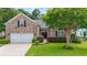 Charming brick home featuring a well-manicured lawn, double-door entrance, and attached two-car garage at 106 Cypress Creek Dr., Murrells Inlet, SC 29576