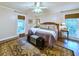Comfortable bedroom featuring a ceiling fan, windows with woven blinds, and hardwood floors with area rug at 1073 Crooked Oak Dr., Pawleys Island, SC 29585