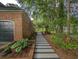 Side view of a brick house with a striped walkway and lush foliage and landscaping at 1073 Crooked Oak Dr., Pawleys Island, SC 29585