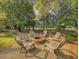Cozy fire pit with seating surrounded by mature trees creates a relaxing outdoor gathering space at 1073 Crooked Oak Dr., Pawleys Island, SC 29585